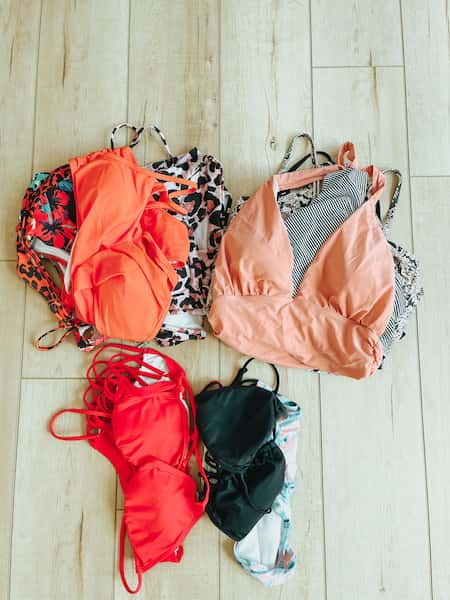 A pile of women's bathing suits separated by style.