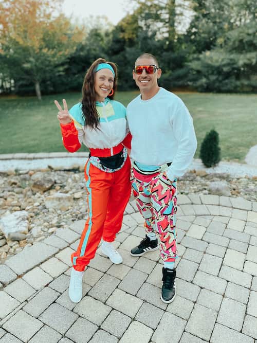 A man and woman dressed up in 80s fashion outfits.