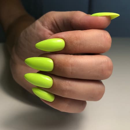 A woman's hand with green nail polish.