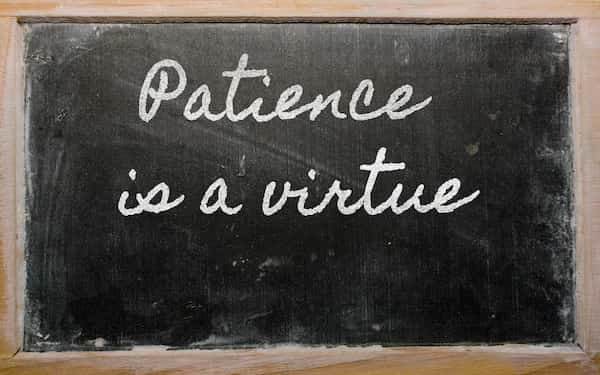 "Patience is a virtue" written on a black chalkboard