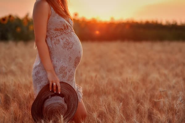 A pregnant woman in a field.
