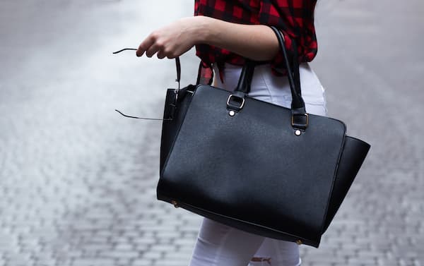 A woman carrying a black handbag. 