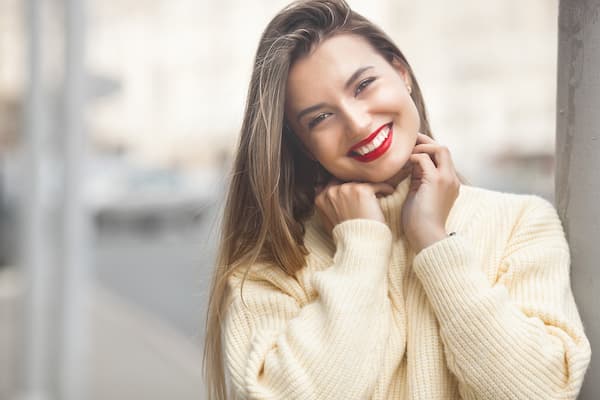 A beautiful smiling woman wearing a cream sweater.