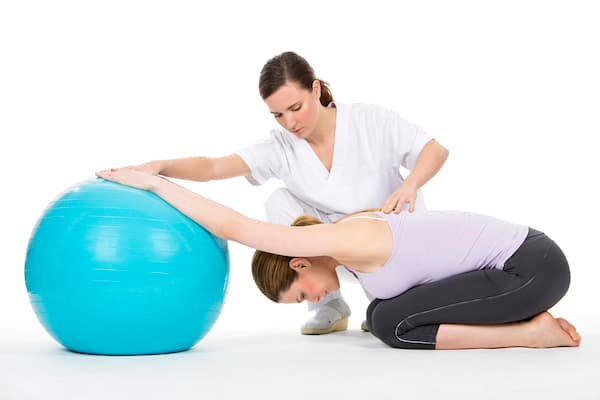 A woman doing an exercise at physical therapy.