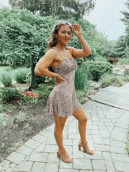 A woman in a brown romper showing a cute pose for instagram.