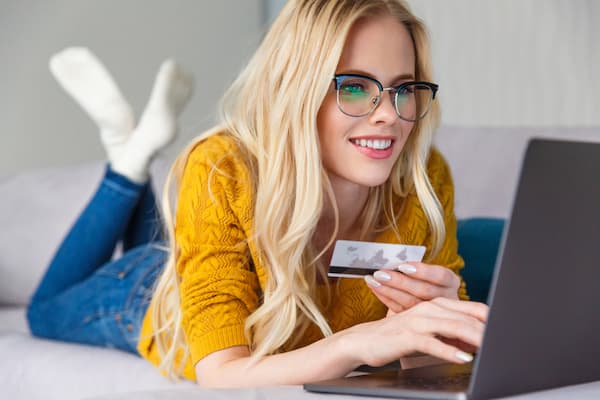 A woman shopping online and holding her credit card.