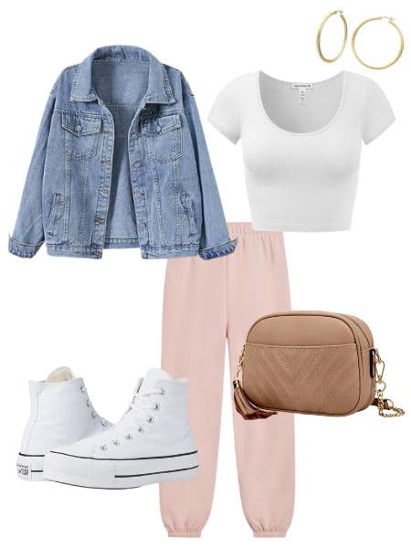 A womens outfit with pink sweatpants, a white crop top, denim jacket, white sneakers, and a tan purse.