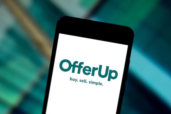 A person holding a phone with the "OfferUp" app open.