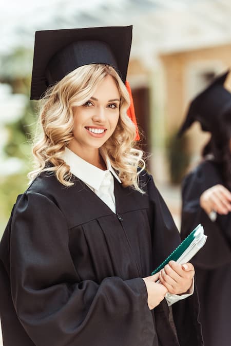 A woman in a cap and gown for graduation.