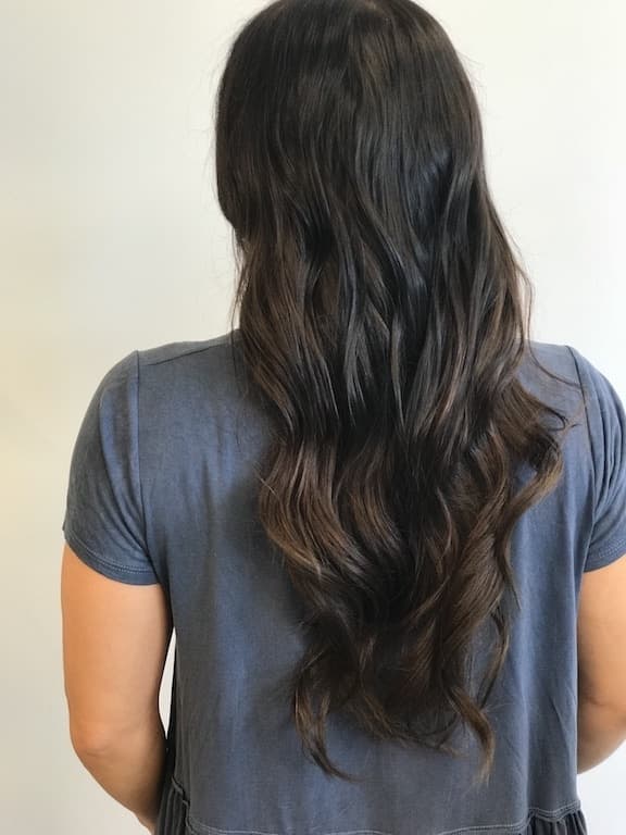 The back of a woman with long dark hair.